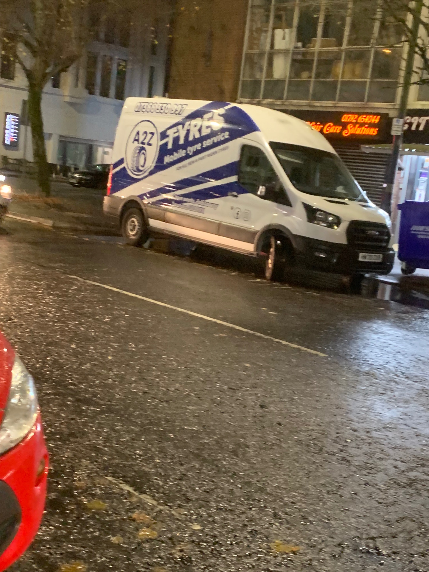 A2Z mobile tyre service van parked on a wet city street at night